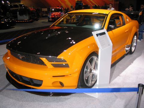 1993 Ford Taurus - This modified Ford Mustang features a two-tone paint scheme and racing-inspired interior elements, likely displayed at an auto show.