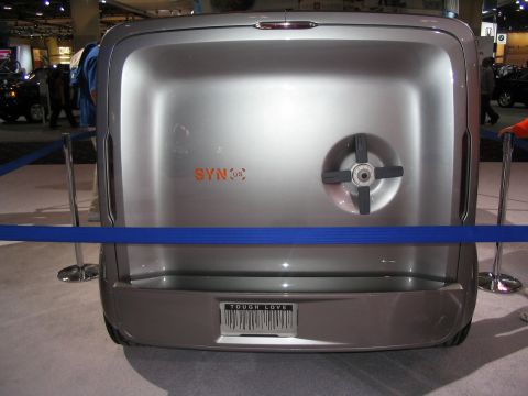 1993 Ford Taurus - Silver concept vehicle with "SYN:us" badging and a "TOUGH LOVE" license plate at an auto show.