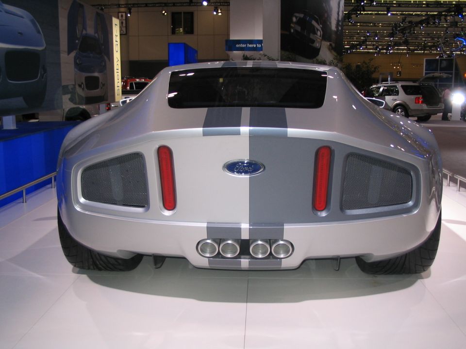 Rear view of a silver Ford concept car with dual racing stripes and quad exhaust pipes
