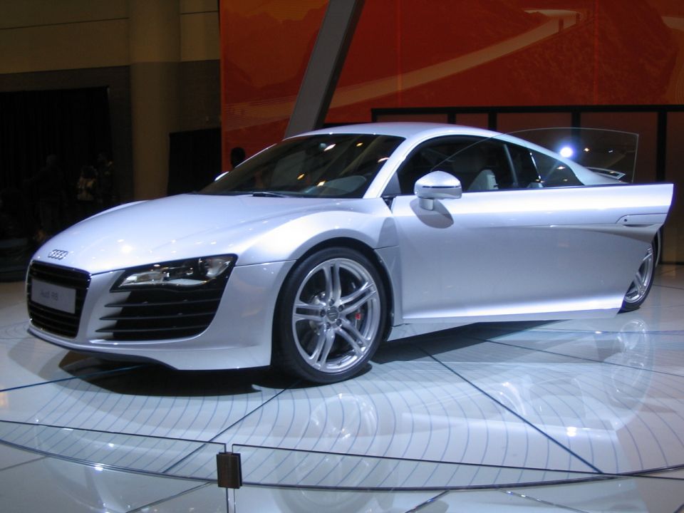 Silver Audi R8 with driver's door open on display floor