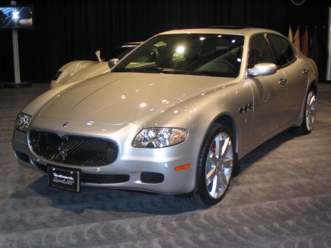 1993 Ford Taurus - A silver Maserati Quattroporte is shown at an auto show with another vehicle in the background.