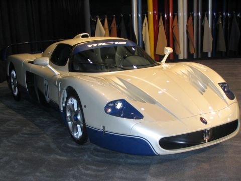 1993 Ford Taurus - A white Maserati MC12 with blue accents is displayed indoors, likely at an auto show.