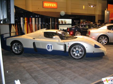 1993 Ford Taurus - A Maserati MC12 race car is displayed at an auto show, with other vehicles visible in the background.