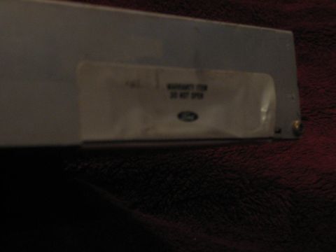 1994 Ford Bronco - A part with a Ford logo and a sticker that reads 'WARRANTY ITEM DO NOT OPEN'.