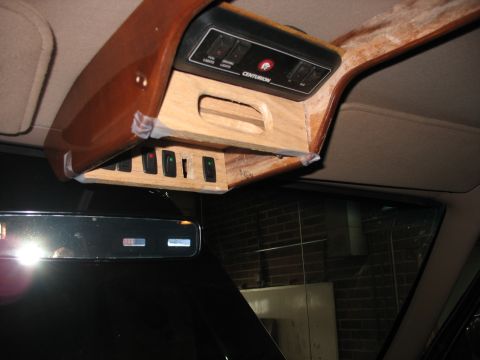 1995 Ford C-350 (Centurion Conversions) - Custom overhead console with numerous switches and unfinished wood trim is installed in a vehicle.