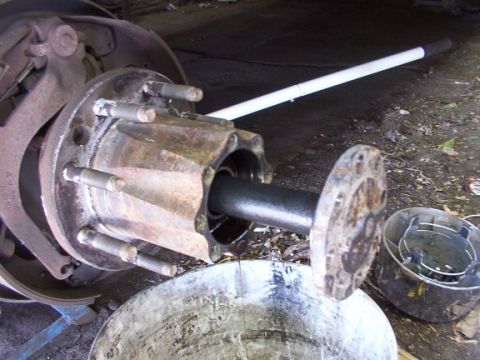 1995 Ford C-350 (Centurion Conversions) - Disassembled truck brake drum and hub assembly, showing the brake drum, studs, and axle shaft.