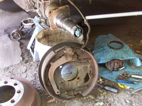 1995 Ford C-350 (Centurion Conversions) - Drum brake assembly components laid out for repair or inspection.