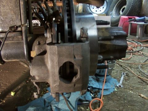 1995 Ford C-350 (Centurion Conversions) - A close-up view of a vehicle's brake caliper and rotor assembly, showing mechanical components.
