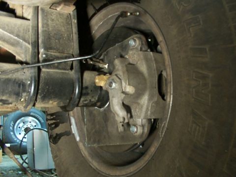 1995 Ford C-350 (Centurion Conversions) - Rear drum brake assembly detail, showing brake lines and suspension.
