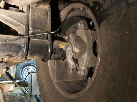 1995 Ford C-350 (Centurion Conversions) - Detail of a vehicle's rear brake system, showing the caliper, rotor, and suspension components.