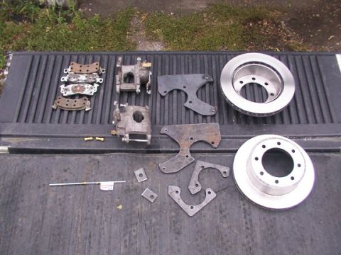 1995 Ford C-350 (Centurion Conversions) - Various brake components, including rotors and calipers, are displayed on a truck bed.
