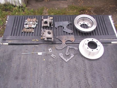 1995 Ford C-350 (Centurion Conversions) - Various brake components are spread across a dark, textured surface, likely a truck bed.