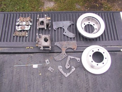 1995 Ford C-350 (Centurion Conversions) - Various brake components, including rotors and calipers, are displayed on a dark, ribbed surface.