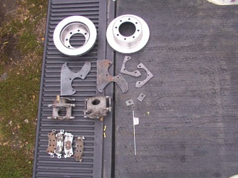 1995 Ford C-350 (Centurion Conversions) - Various brake components are arranged on a dark, ribbed surface, possibly a truck tailgate.