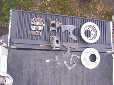 1995 Ford C-350 (Centurion Conversions) - Various brake components are arranged on the ribbed surface of a pickup truck's bed.