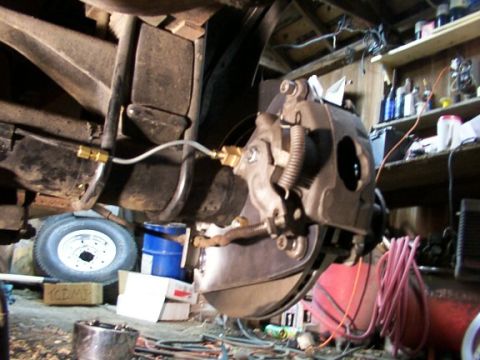 1995 Ford C-350 (Centurion Conversions) - Close-up of a vehicle's brake system, showing the caliper, rotor, and brake line.
