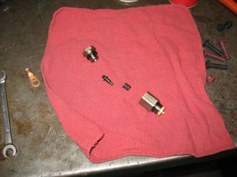 1995 Ford C-350 (Centurion Conversions) - Disassembled brake caliper piston and associated components laid out on a red cloth with tools nearby.