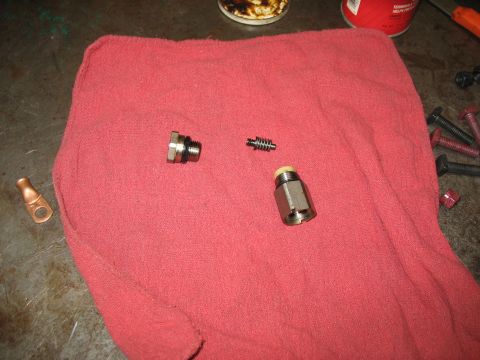 1995 Ford C-350 (Centurion Conversions) - Brake caliper piston and bleed screw laid out on a red cloth with other hardware.