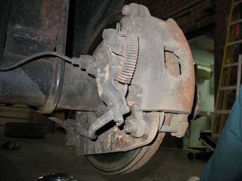 1995 Ford C-350 (Centurion Conversions) - Close-up of a vehicle's rear drum brake assembly, showing the caliper and brake line.