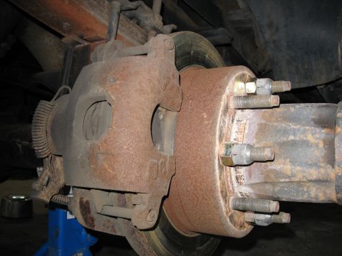 1995 Ford C-350 (Centurion Conversions) - This photo shows a heavily rusted brake caliper and rotor assembly, indicating a need for maintenance or replacement.