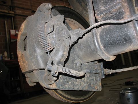1995 Ford C-350 (Centurion Conversions) - Close-up view of a vehicle's rear brake caliper and rotor assembly.