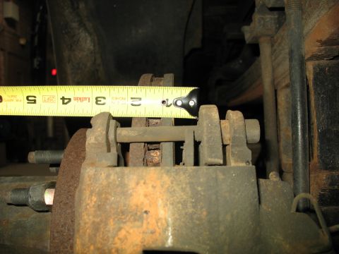 1995 Ford C-350 (Centurion Conversions) - Close-up of a Sterling disc brake caliper, with a tape measure indicating a measurement of approximately 3 inches.