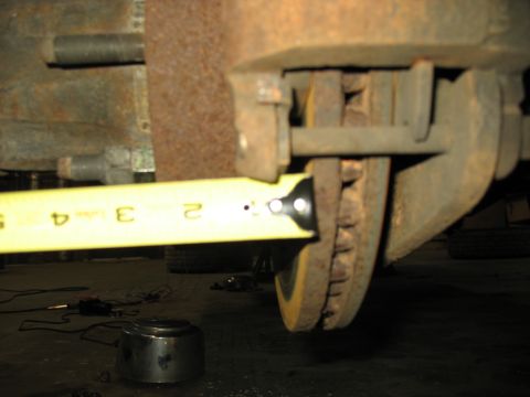 1995 Ford C-350 (Centurion Conversions) - A close-up view of a vehicle's brake assembly, with a measuring tape indicating a dimension.