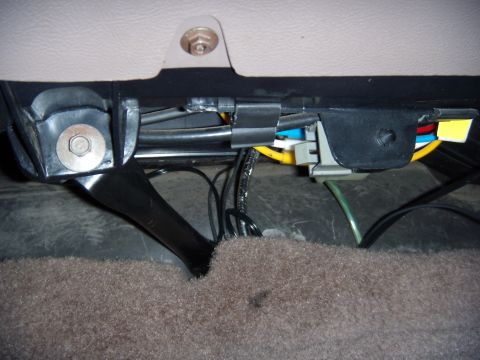 1992 Ford Bronco - Close-up view of the wiring harness located beneath the vehicle's seat.