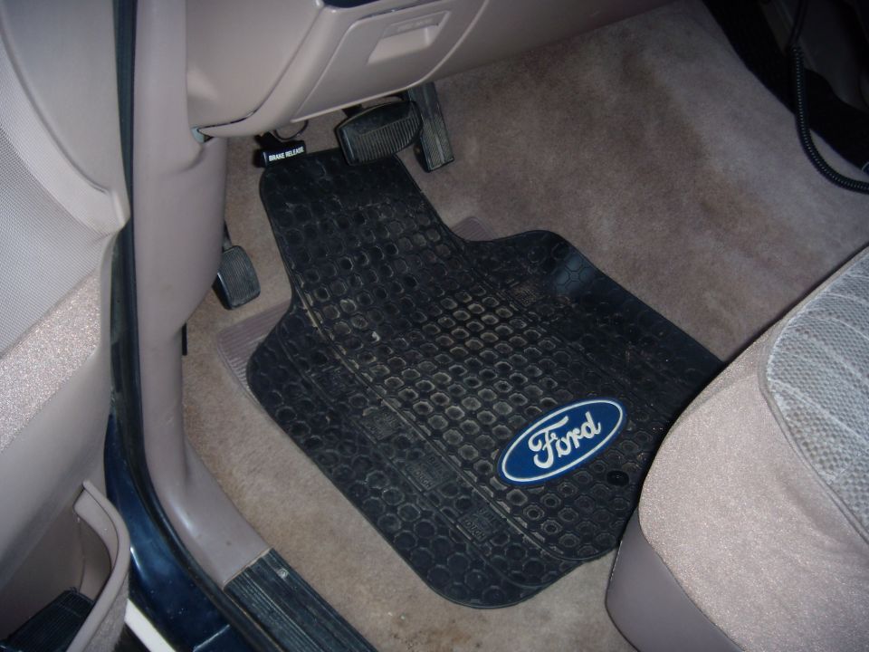 Driver's side floor mat with Ford logo, brake and gas pedals visible