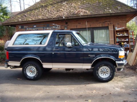 1992 Ford Bronco - Side profile of a 1992 Ford Bronco, a two-tone paint scheme and a roof rack.