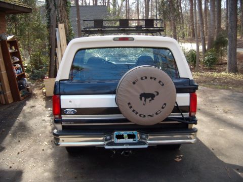 1992 Ford Bronco - Rear view of a 1992 Ford Bronco, equipped with a spare tire cover and roof rack.