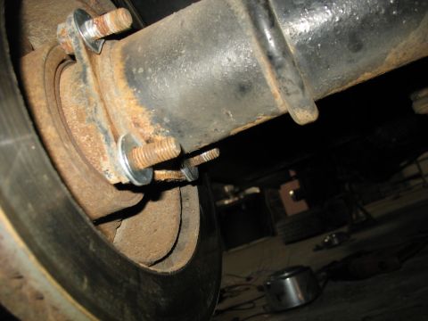 1995 Ford C-350 (Centurion Conversions) - Close-up view of a rusted rear axle brake assembly, showing bolts and washers.
