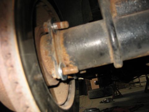 1995 Ford C-350 (Centurion Conversions) - Detail of a vehicle's rear axle and brake system, showing wear and rust.