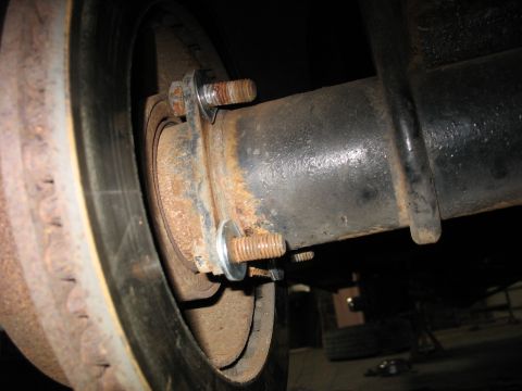 1995 Ford C-350 (Centurion Conversions) - Rear axle and brake assembly detail, showing rust and hardware.