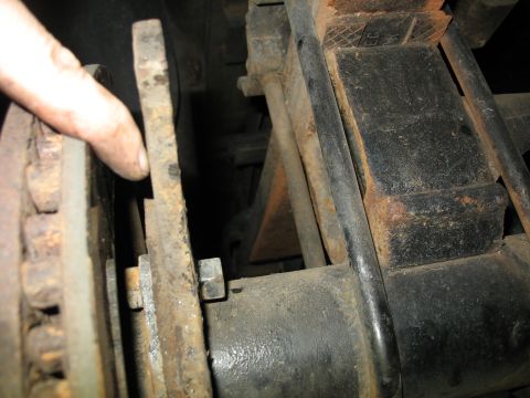 1995 Ford C-350 (Centurion Conversions) - Close-up of a brake caliper and leaf spring assembly, showing signs of rust.