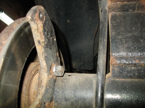 1995 Ford C-350 (Centurion Conversions) - Close-up view of a rusty brake rotor and suspension components.