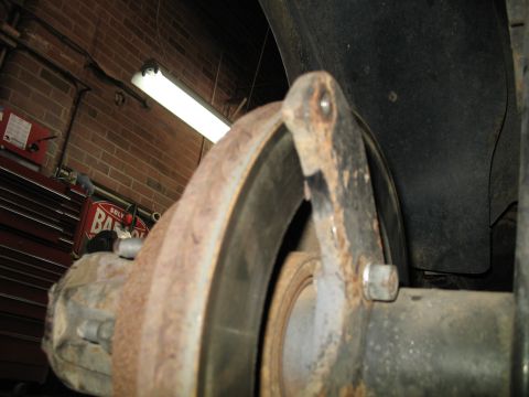 1995 Ford C-350 (Centurion Conversions) - Focus on a rusty brake rotor and caliper bracket, suggesting a repair or maintenance context.