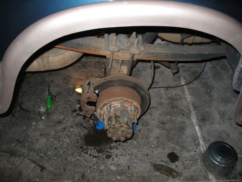 1995 Ford C-350 (Centurion Conversions) - Close-up of a vehicle's rear axle and brake system, likely undergoing maintenance or repair.