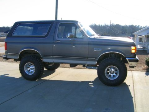 1989 Ford Bronco - This lifted 1989 Ford Bronco has large off-road tires and a dark gray paint job.