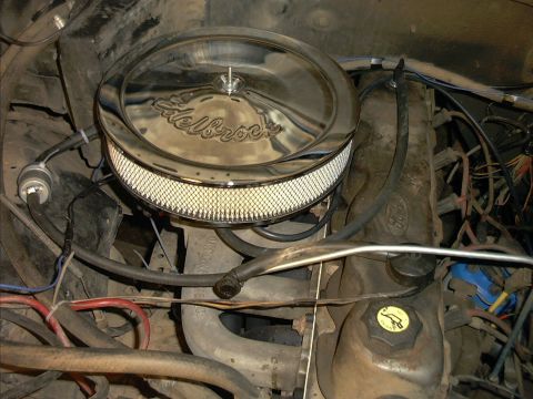 1985 Ford Bronco - Engine bay view showing a chrome round Edelbrock air cleaner with pleated white filter mounted atop the carburetor. Surrounding the engine…