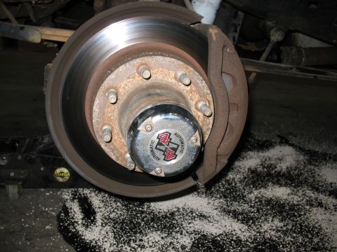 1995 Ford C-350 (Centurion Conversions) - Detail of a vehicle's front wheel hub assembly, showing a locking hub and brake rotor.