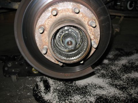 1995 Ford C-350 (Centurion Conversions) - Close-up of a vehicle's front wheel hub and brake rotor assembly, showing internal splines.