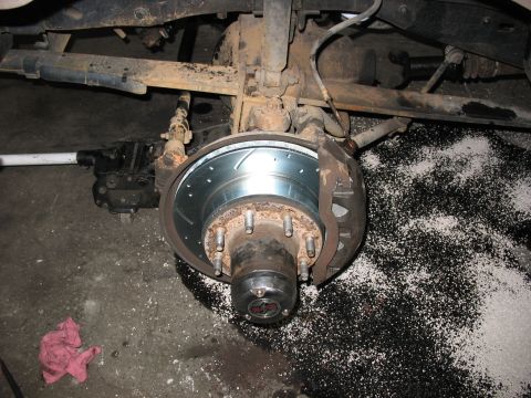 1995 Ford C-350 (Centurion Conversions) - Close-up of a vehicle's rear axle and brake system, showing a new rotor and caliper.