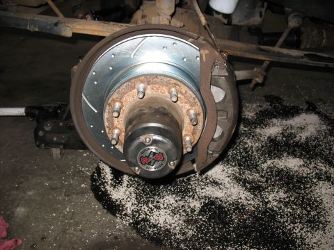 1995 Ford C-350 (Centurion Conversions) - Close-up of a front wheel hub assembly a new drilled and slotted brake rotor and caliper. The hub cap indicates it is an "AUTOMATIC LOCK-O-…