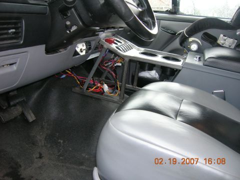 1996 Ford Bronco - The interior of a vehicle is shown, with a focus on the center console and exposed wiring, along with the seats and dashboard.