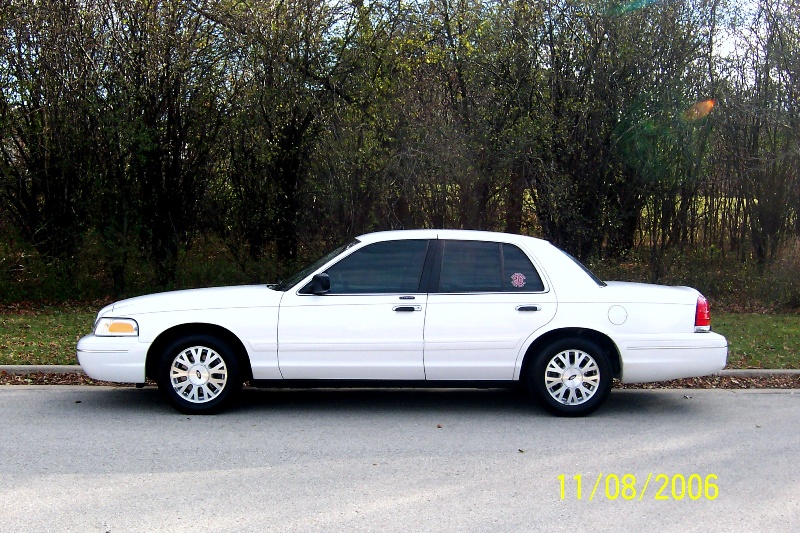White 2003 Ford Crown Victoria sedan parked on asphalt, side view