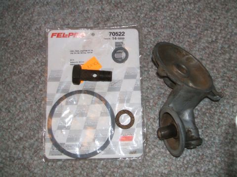 1974 Dodge Challenger - Oil filter housing and gasket set are laid out on a carpeted surface.