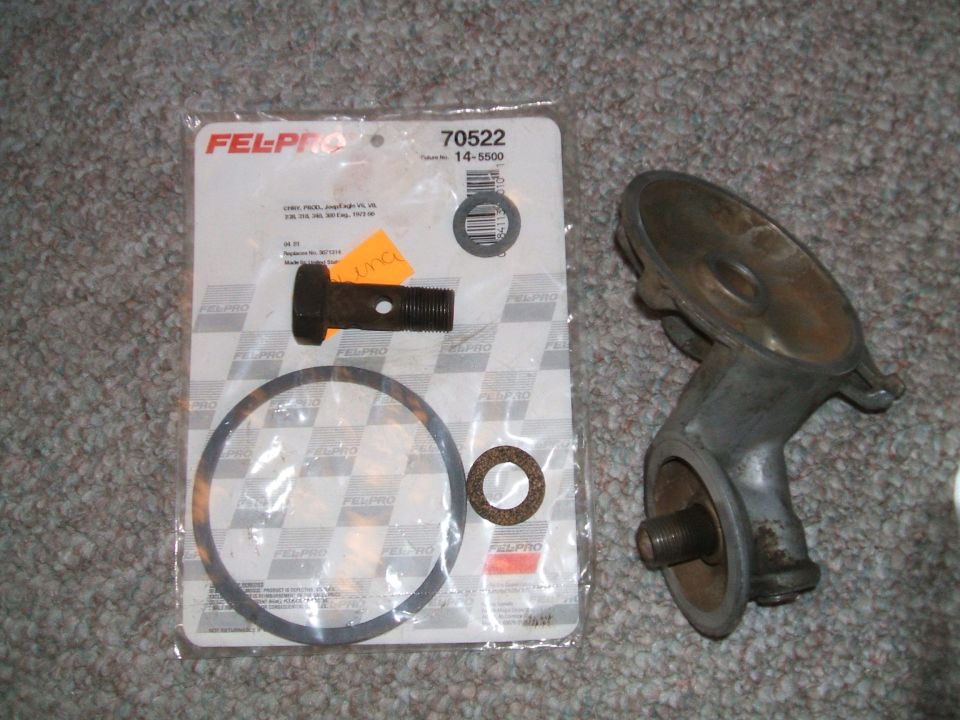 Oil filter housing and Fel-Pro gasket set with bolt and washer on carpet
