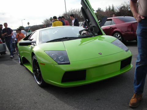 1998 Ford Crown Victoria - lime-green Lamborghini Murcielago with one scissor door open and black wheels sits among crowds at a car show.