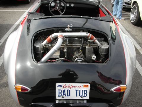 1998 Ford Crown Victoria - Rear of a black-and-silver vintage roadster with an exposed rear engine and a California 'BAD TUB' license plate.
